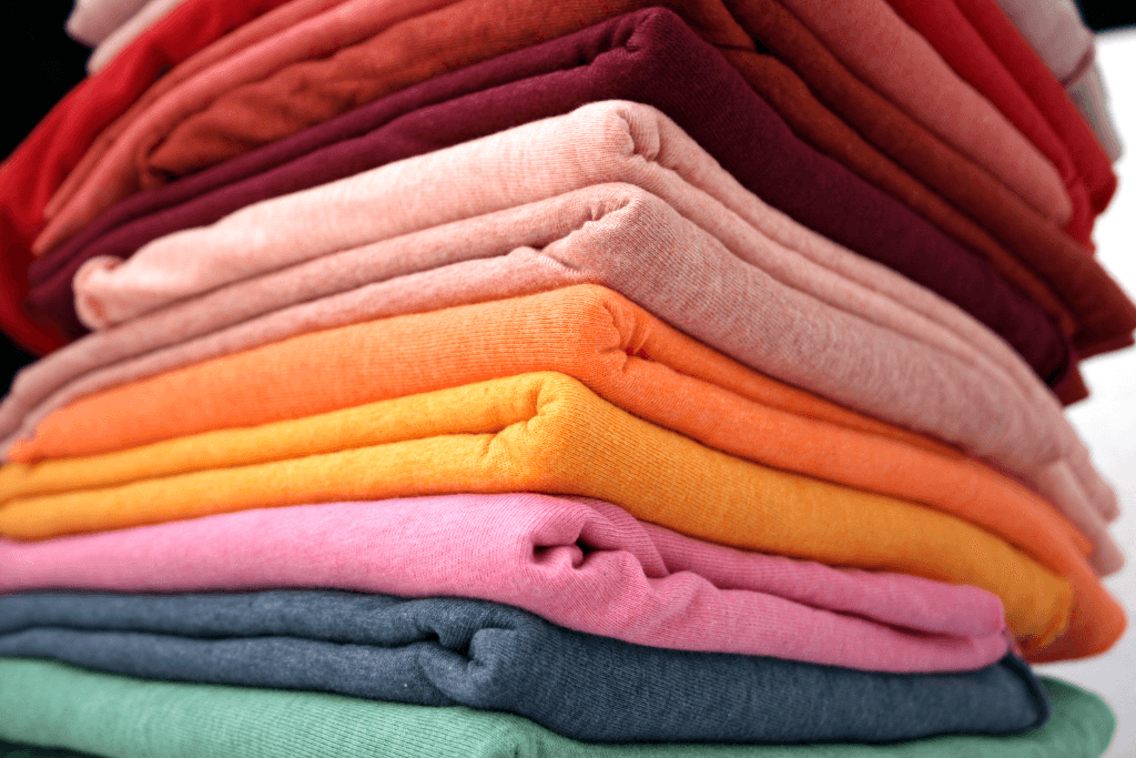 Các thẻ minh họa thời trang bày trên bàn gỗ, thể hiện nhiều kiểu trang phục đa dạng như quần ống rộng, áo sơ mi, váy dài, suit… mô tả những ứng dụng phổ biến của chất liệu cotton lạnh trong thiết kế trang phục.